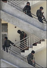 Afghan counter-terrorism soldiers drag the dead body of a militant down the stairs of a bank in Kabul, Afghanistan, Wednesday, Aug. 19, 2009 after gun battles broke out between Afghan forces and three militants with AK-47 rifles and hand grenades who overran a bank. Police stormed the building and killed the three insurgents, officials said. (AP Photo/Rafiq Maqbool)